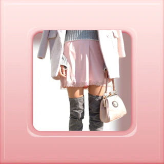 cropped image of a women wearing a soft pink skirt, black boots, white over coat and a white handbag 