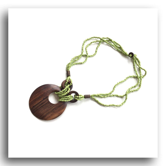 Wood pendant suspended on multi-strand torsade necklace